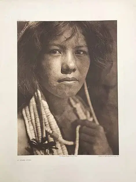A young adult Pomo girl, looking straight into the camera.