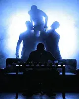 4 male dancers in shadow during a staged performance