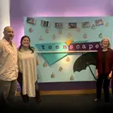 3 journalists in front of teenscape sign