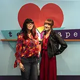 2 women in front of the teenscape sign