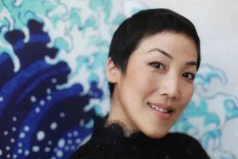 traci kato-kiriyama in front of a blue wave painting