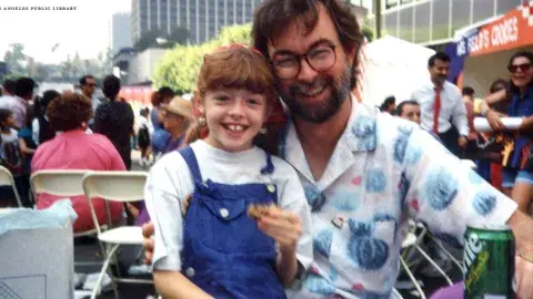 Glen Creason and his daughter Katya celebrate the re-opening of Central Library on a closed-off 5th Street