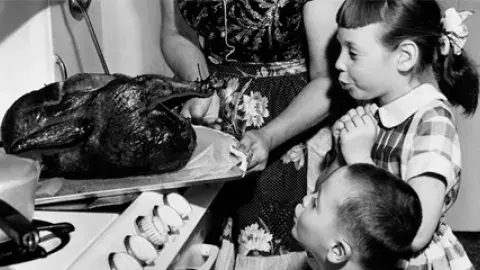 children oohing at turkey coming out of the oven
