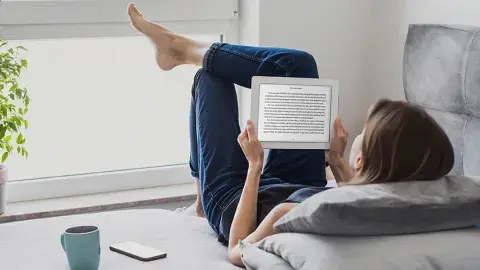 Girl reading a book on her tablet