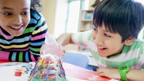 Happy kids working on a volcano experiment