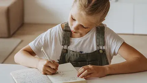 Young girl writing in her journal