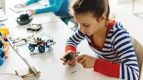 Young girl building an electronic device