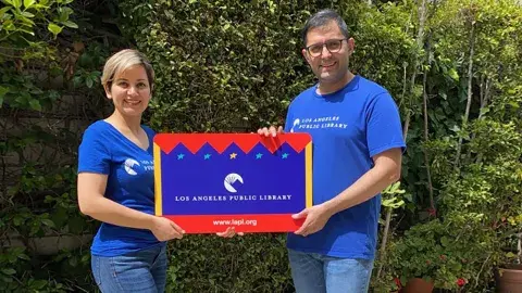 LAPL librarians - Ramin and Toktam holding large LAPL library card