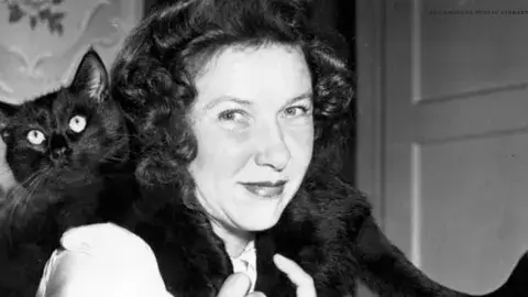 women with a black cat slung over her shoulders