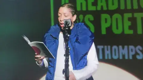 Lynne Thompson reading potery at an event