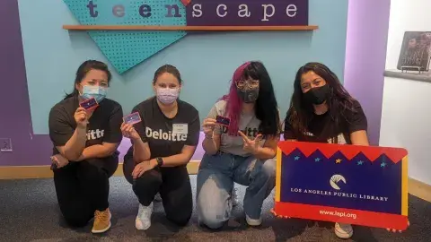 Teen’Scape sign with Michelle, Ashley, Julia, and a teen volunteer