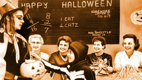 Judy Aldrich, 8, receives pumpkin treat from Donna Lewis