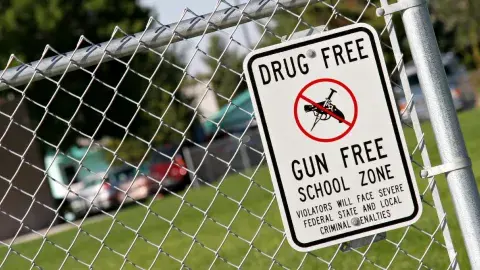 chainlink fence with a sign that reads drug free gun free school zone