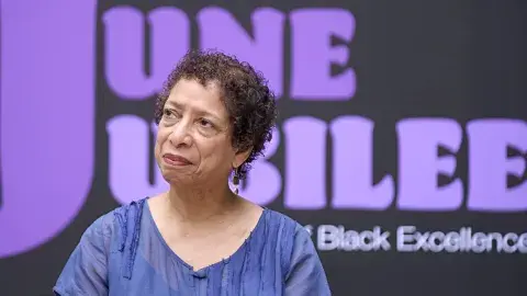 Poet Lynne Thompson in front of LAPL's June Jubilee banner