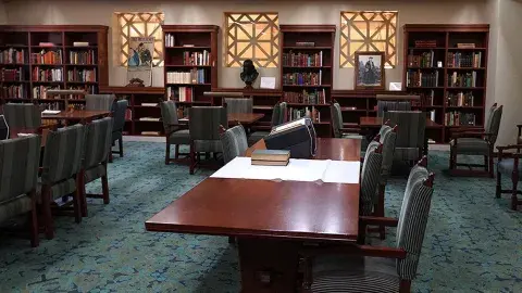 In the Rare Books room, rare books are set on top a white cloth over a table for a preview.