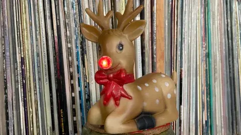 record wall with a giant Rudolph ornament in front