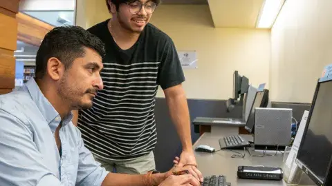 person helping someone with the computer