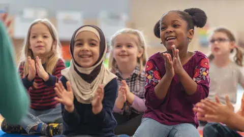 kids sitting and clapping