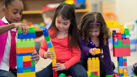 Three girls playing with toy blocks