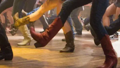 dancing legs in jeans and cowboy boots