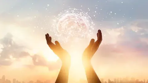 Two hands reach into the sky holding a ball of light