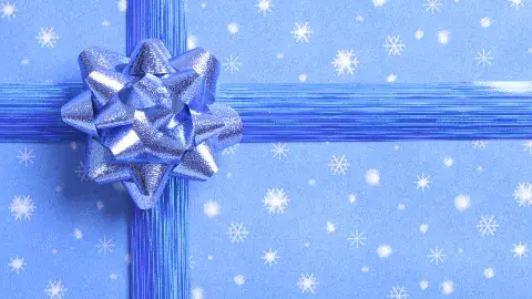 Blue wrapping paper with snowflake design and blue ribbon bow