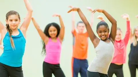 Children are waiving their arms while exercising.