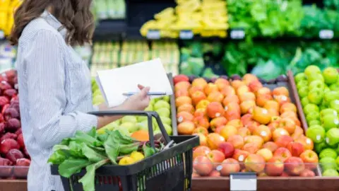 A woman shopping for vegetables in the produce section.