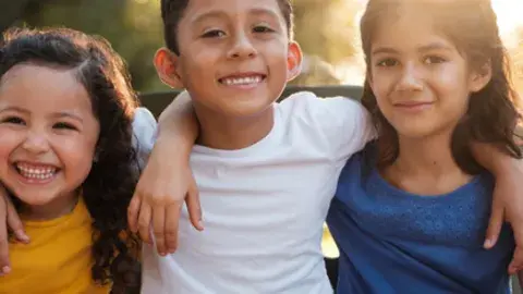 young children girls and boys smiling with arms around each other