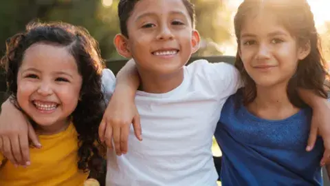 young children girls and boys smiling with arms around each other