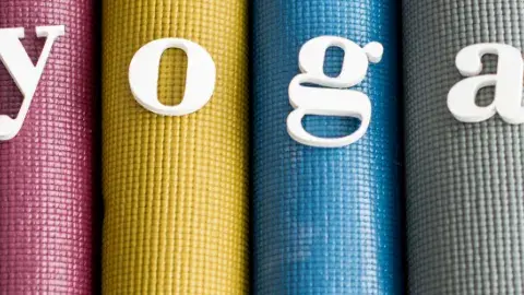 4 colorful yoga mats, rolled up