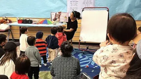 Volunteer reading to a group of kids. 