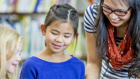 Two children listens to an adult reading to them