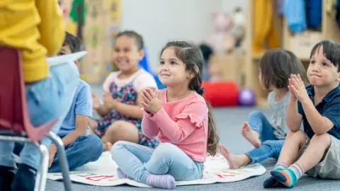 Toddlers seated on the floor listening to a story