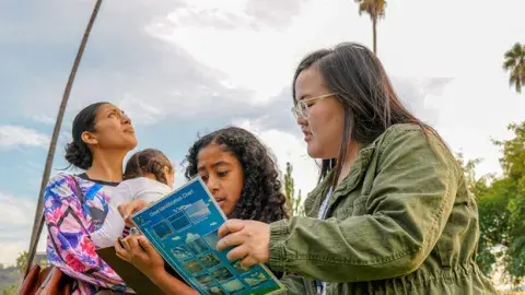 kids participating in a cloud identification class outside the library