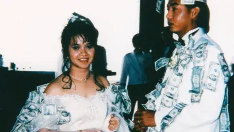 Wedding couple covered in money during a "dollar dance."