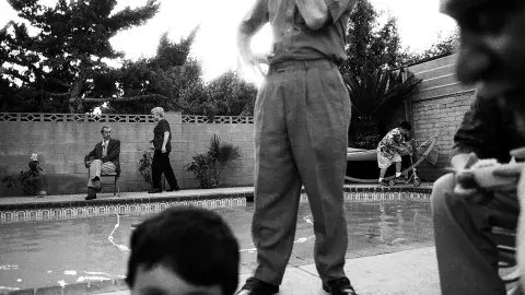 black and white photo of family by swimming pool