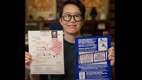 person holds up two different menus