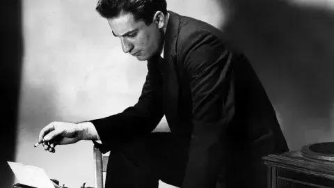 Black and white photo of person using typewriter