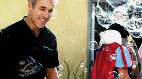 A man smiles surrounded by bubbles