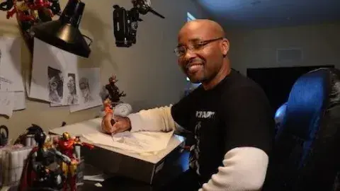 Animator Evan Burse posing at his desk