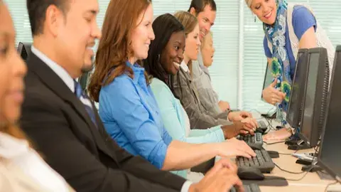 Men and women sitting and using computers