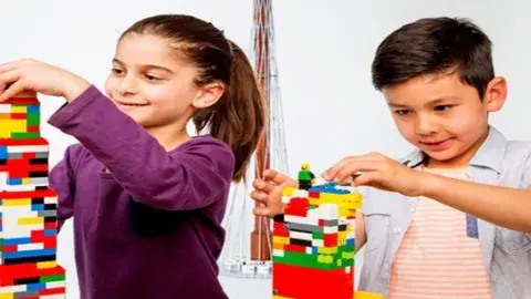 Two kids building with legos