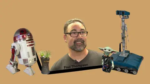 Image of Paul Thompson being surrounded by some of his robotic creations