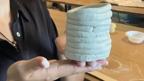 hands holding a clay sculpture