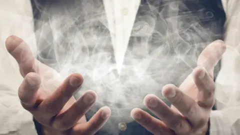 hands with wispy smoke floating out of them like magic