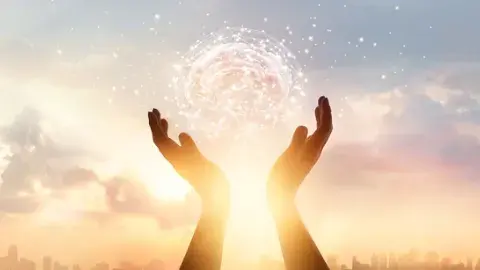 Hands reaching upwards holding the sun
