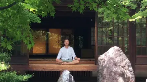 Meditation guide seated on a platform
