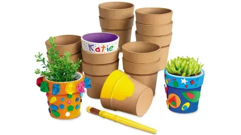 stacks of small gardening pots, with several that are painted and decorated and a yellow paintbrush