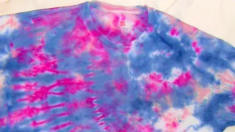 A vibrant tshirt that has been tie-dyed in pink and blue.